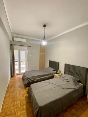 a bedroom with two beds and a pendant light at Sweety Flat Marina Zeas Piraeus in Piraeus