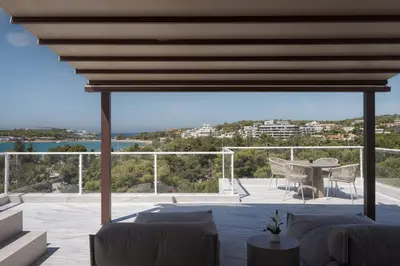 a patio with a table and a view of the water at The Vouliagmeni Penthouse in Athens