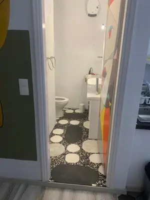 a bathroom with a toilet and a doorway with ailed floor at Manello Home Art in Athens