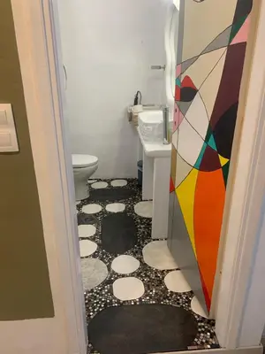 a bathroom with a toilet and a mosaic floor at Manello Home Art in Athens