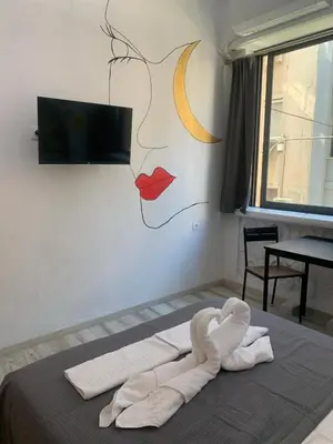 a bed with a towel laying on top of it at Manello Home Art in Athens