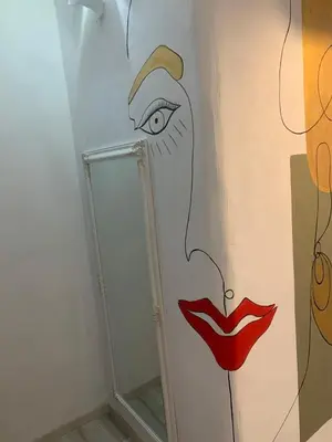 a bathroom with a mirror and a painting of a woman at Manello Home Art in Athens