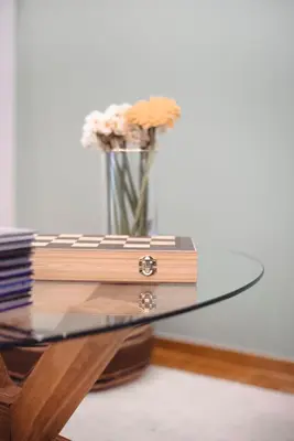 a glass table with a vase with flowers on it at Mary's Haven Apt near metro station and Acropolis in Athens