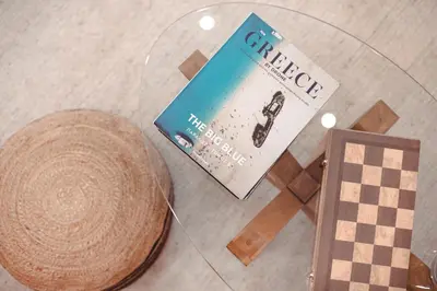 a book and a straw hat on a glass table at Mary's Haven Apt near metro station and Acropolis in Athens