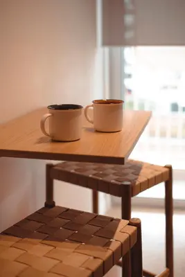 two coffee cups sitting on a wooden table at Mary's Haven Apt near metro station and Acropolis in Athens