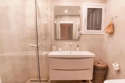a white bathroom with a sink and a shower at Mary's Haven Apt near metro station and Acropolis in Athens