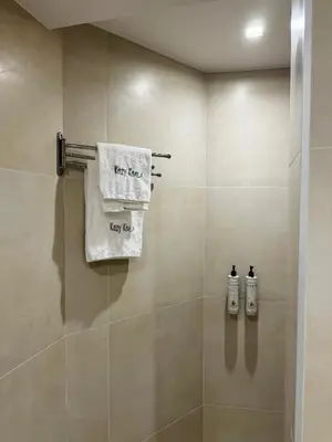 a bathroom with a shower stall with two towels at Charming 2BR Basement near Akropolis Athens by Kozy Koala in Athens