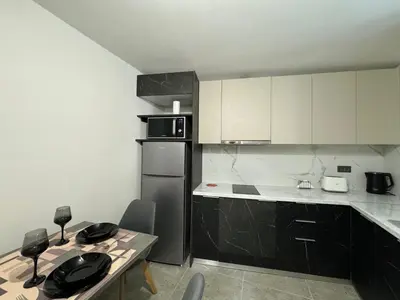 a small kitchen with a table and a refrigerator at Charming 2BR Basement near Akropolis Athens by Kozy Koala in Athens