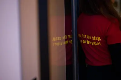 a person in a red shirt with a sign on a window at Retroverse Eccentric Stay in Athens