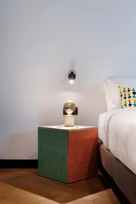 a bedroom with a bed and a table with a lamp at Retroverse Eccentric Stay in Athens