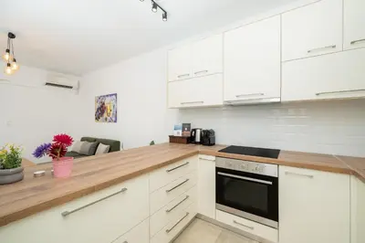 a kitchen with white cabinets and a wooden counter top at DOMUS by A&D Properties in Porto Rafti