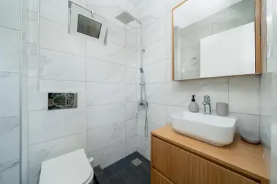 a white bathroom with a sink and a shower at DOMUS by A&D Properties in Porto Rafti