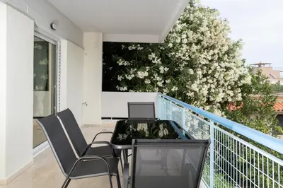 a balcony with a table and chairs and a tree at DOMUS by A&D Properties in Porto Rafti