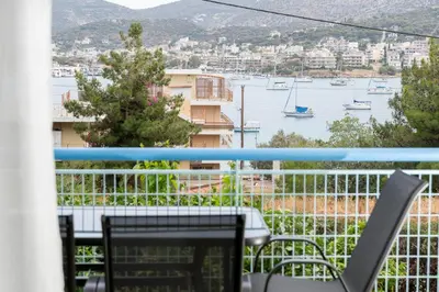 a balcony with a table and chairs and a view of a harbor at DOMUS by A&D Properties in Porto Rafti