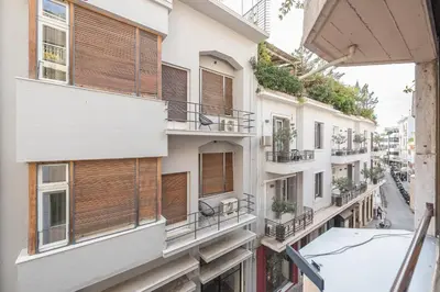 an apartment building with wooden shutters on the balconies at Apartment Steps From Historic Center Plaka in Athens