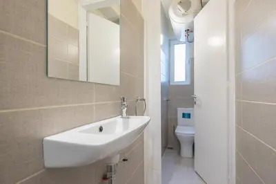 a bathroom with a white sink and a toilet at Apartment Steps From Historic Center Plaka in Athens