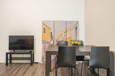 a dining room with a table and chairs and a television at Apartment Steps From Historic Center Plaka in Athens