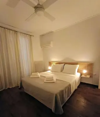a bedroom with a bed with two towels on it at Cozy Garden House in the center of Glyfada in Athens
