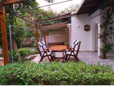 a patio with a table and chairs in a backyard at Cozy Garden House in the center of Glyfada in Athens