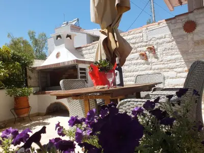a table and chairs with purple flowers on a patio at Maria's Apartment Next to Alimos Metro Station in Athens