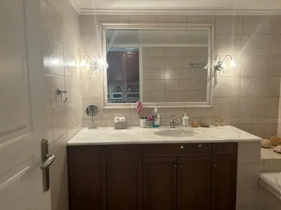 a bathroom with a sink and a mirror at Maria's Apartment Next to Alimos Metro Station in Athens