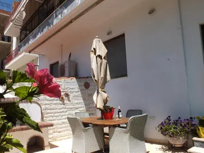 a table and chairs with an umbrella on a patio at Maria's Apartment Next to Alimos Metro Station in Athens