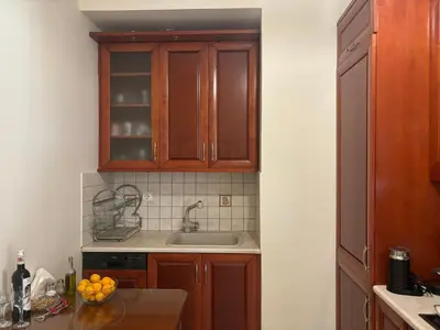 a kitchen with wooden cabinets and a sink at Maria's Apartment Next to Alimos Metro Station in Athens