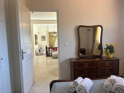 a bedroom with a mirror and a bed with towels at Maria's Apartment Next to Alimos Metro Station in Athens