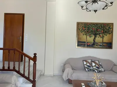 a living room with a couch and a painting on the wall at Maria's Apartment Next to Alimos Metro Station in Athens