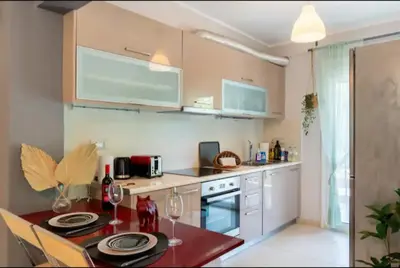 a kitchen with a table with wine glasses on it at Vouliagmeni Thalassa Apartment in Athens