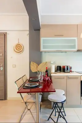 a kitchen with a red table and chairs in a room at Vouliagmeni Thalassa Apartment in Athens