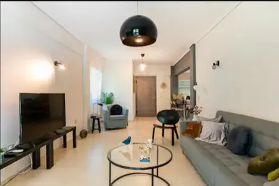a living room with a couch and a table at Vouliagmeni Thalassa Apartment in Athens