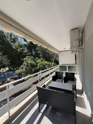 a balcony with two chairs and a table on a building at Vouliagmeni Thalassa Apartment in Athens