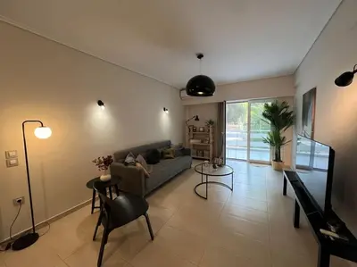 a living room with a couch and a table at Vouliagmeni Thalassa Apartment in Athens