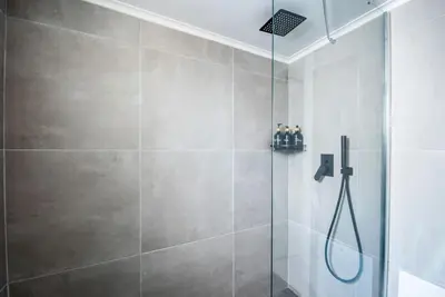 a shower with a glass door in a bathroom at Sunlight rooftop apartment in Athens