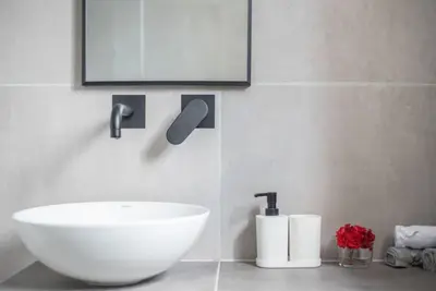 a bathroom with a white sink and a tv on the wall at Sunlight rooftop apartment in Athens