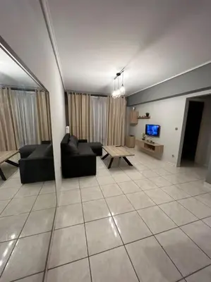 a living room with couches and a table and a tv at D2 Apartment - Athens Oasis in Athens