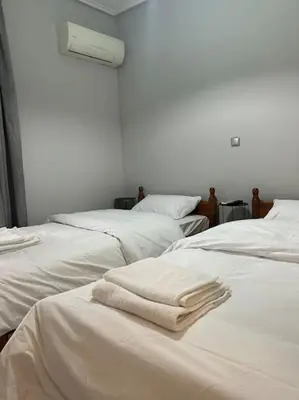 a room with three white beds with towels on them at D2 Apartment - Athens Oasis in Athens