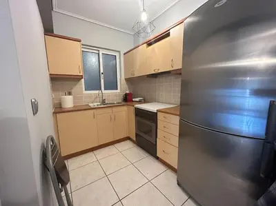 a kitchen with a stainless steel refrigerator and wooden cabinets at D2 Apartment - Athens Oasis in Athens