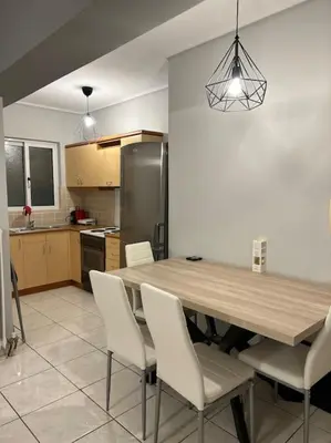 a kitchen with a wooden table and white chairs at D2 Apartment - Athens Oasis in Athens