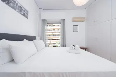 a white bedroom with a large white bed with two white pillows at Sea Breeze 2 bedroom Apartment - 10 min walk to beach in Athens