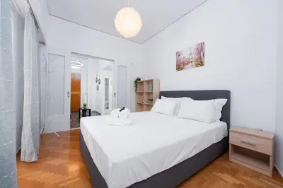 a bedroom with a large white bed in a room at Sea Breeze 2 bedroom Apartment - 10 min walk to beach in Athens