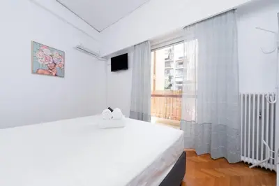 a white room with a bed and a window at Sea Breeze 2 bedroom Apartment - 10 min walk to beach in Athens