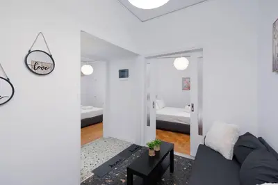 a living room with a couch and a bedroom at Sea Breeze 2 bedroom Apartment - 10 min walk to beach in Athens