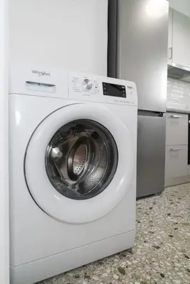 a white washing machine sitting in a kitchen at Sea Breeze 2 bedroom Apartment - 10 min walk to beach in Athens