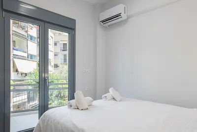 a bedroom with a white bed and a window at SoulPoint Near City in Athens