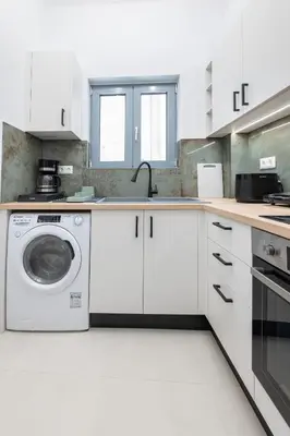 a white kitchen with a washing machine in it at SoulPoint Near City in Athens