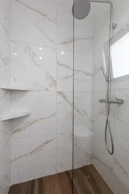 a bathroom with a shower with white marble walls at SoulPoint Near City in Athens