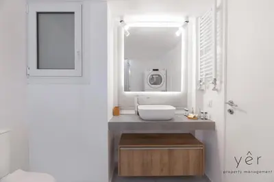 a white bathroom with a sink and a mirror at Free-Spirit Large Boho Apartment with Free-Parking in Athens