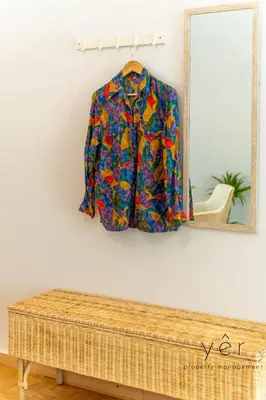 a jacket hanging on a wall next to a mirror at Free-Spirit Large Boho Apartment with Free-Parking in Athens